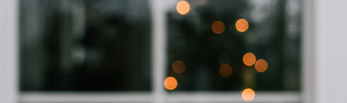 Window lit by a Christmas tree and warm fairy lights